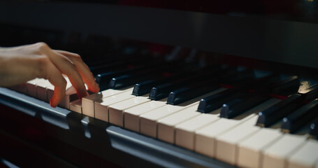 Fototapeta premium Close Up on an Anonymous Pianist Performing Classical Instrumental Music on Stage. Female Musician Using a Grand Piano to Create Beautiful, Melodic Jazz Improvisation. Hands Moving Across the Keys