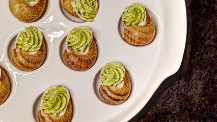 Close up of delicious escargot on a white plate, snails backgrounds