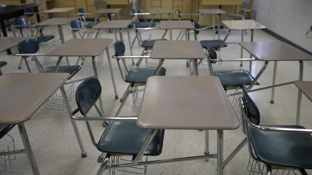 The classroom features multiple empty desks ready for students, reflecting a learning environment awaiting educational activities to begin.