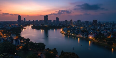 Fototapeta premium A beautiful city with a river flowing through it, during the evening. The setting sun casts a warm golden glow over the skyline, reflecting on the calm water below.