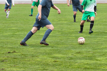 One attacking soccer player in a blue uniform is preparing to pass the ball forward, developing an attack in football