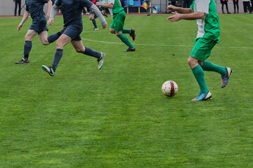 A football player with the ball is looking for an opportunity to pass to teammates, a soccer player...