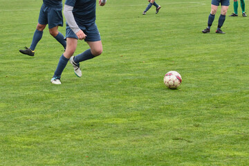 Obraz premium An attacking soccer player with the ball, fighting for victory in the match. A footballer in action at a tournament game.