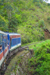 Naklejka premium Colonial train route built by the British Empire, offering a journey through history, stunning mountains, waterfalls, and tea estates—Ella Odyssey train journey 2024.12.13 Ella Sri Lanka