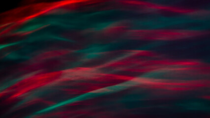 Defocused abstract red and green background of speed camera movement over glowing lights. A pattern of flashes of light similar to the northern lights
