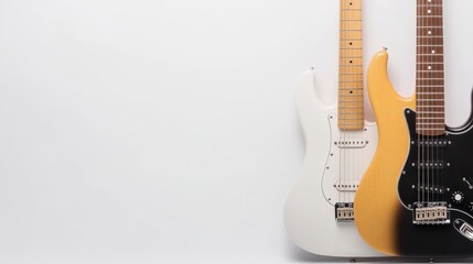 Fototapeta premium Two electric guitars, one white and one yellow, positioned side by side against a plain background, showcasing their unique designs and colors.