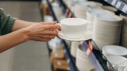 White new cup. Close up view of woman that is in the hardware store