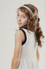 Young girl with curly hair looking back