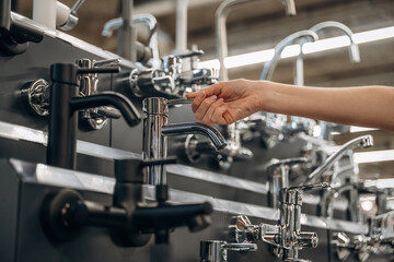 Tap for kitchen. Close up view of woman that is in the hardware store