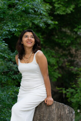 Fototapeta premium Latin woman posing in nature wearing a white dress