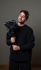 ragazzo videomaker con macchine fotografica e stabilizzatore
