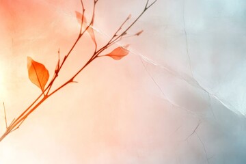 Delicate branches with orange leaves against a soft pastel background highlighting seasonal change and nature's beauty