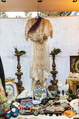 London, UK - December 4, 2024: Vintage silk dress in 1920s style, wooden candlesticks, figurines,...