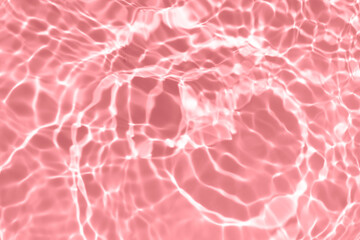 Pink water bubbles on the surface ripples. Defocus blurred transparent pink colored clear calm water surface texture with splash and bubbles. Water waves with shining pattern texture background