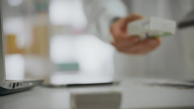 Pharmacy worker pharmacist gives medicines to a customer. Close-up of hand movement with a box of medicines. Customer picks up medicines in a pharmacy near the counter
