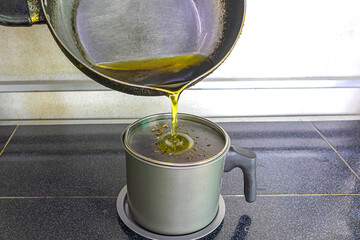Pour the used cooking oil into the contaminated cooking oil container. 