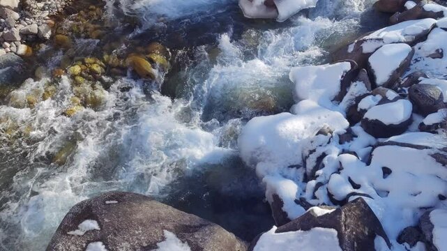  cold mountain river with ice and snoe in Kyrgyzstan