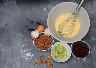 Ingredients for making cookies on a table. Top view photo of raisins, nuts and dried cranberries on a gray background with space for text. Healthy eating concept. 
