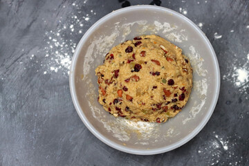 Close up photo of sugar free dough in a bowl. Preparation of dough for cookies with raisins and cranberries, Eating healthy concept. 