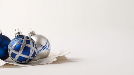 Festive Celebration: Decorative Hanukkah Ornaments with Shiny Blue and Silver Designs Placed on Torn Paper