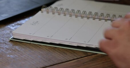 Blank weekly planner lays open on wooden desk beside laptop, ready for scheduling tasks events.