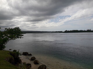 Aceh Beach during the day, showing a beautiful view between the beach, sand, land, and sky. Aceh Beach is located on Simeulu Island, Sinabang- Indonesia.