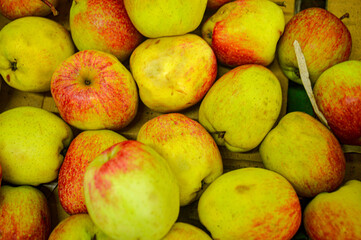 Green red fruits in a fruit shop basket. Focus on fruit, noisy, exposure, similar others