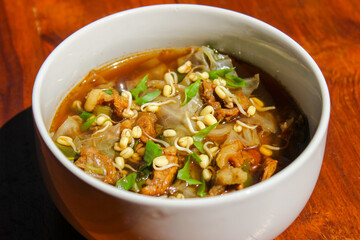Close up photo of Rawon (Indonesian beef soup). It is originating from East Java, rawon utilizes the black keluak nut as the main seasoning, which gives a dark color and nutty flavor to the soup.