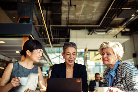 Diverse professional business people having meeting in modern cafe