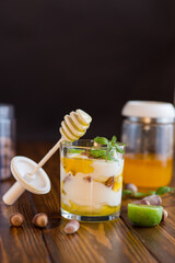 homemade yogurt with kiwi, honey and nuts in a glass on a wooden table