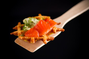 vegetable potato waffles with spread and lightly salted red fish on a spatula