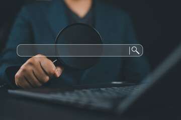 Businessman using a laptop show a search bar. Concept of keyword search engines, SEO optimization,...