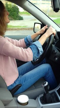 Woman showing rage, frustration and anger while hitting the steering wheel of her car hard.vertical interior.