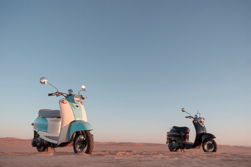 Two Retro scooters at sunset in the golden sand of the Namib Desert