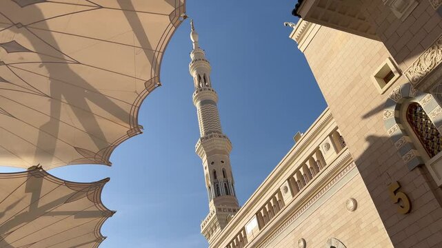 Al-Masjid an-Nabawi (Prophet's Mosque) in Medina city, Saudi Arabia against the background of blue clear sky with place for text. Islamic background for Eid al Fitr Eid al Adha.