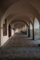 Arched corridor in prague creating a tunnel effect with cobblestone floor