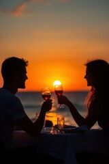 Silhouette of a young couple toasting with wine glasses at sunset on a romantic date in summer.