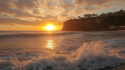 Obraz premium Sunset over the ocean with waves crashing on the shore.