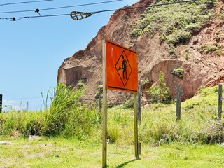 Placa na rodovia de homem trablhando em obras.