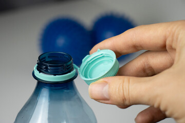 Female hands open a bottle. Water bottle close-up. Plastic bottle cap. Copy space. Thirst, dehydration