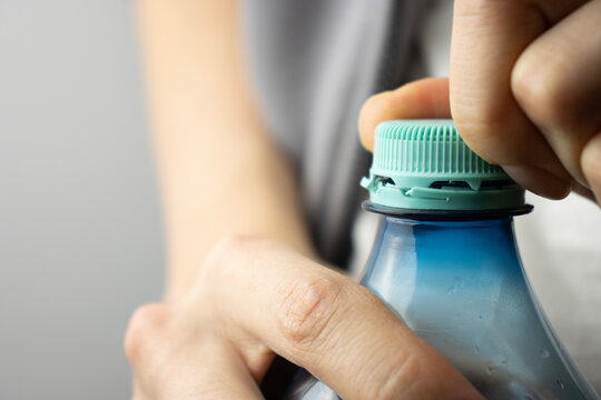 Female hands open a bottle. Water bottle close-up. Plastic bottle cap. Copy space. Thirst, dehydration