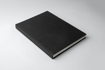 Blank black vertical book cover isolated on white paper background.