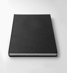 Blank black vertical book cover isolated on white paper background.