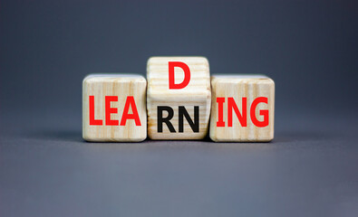 Learning or leading symbol. Concept words Learning Leading on wooden block. Beautiful grey table...