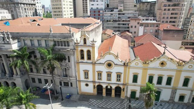View of Largo de S&atilde;o Francisco in S&atilde;o Paulo, featuring the historic USP Law School building with its neoclassical architecture, surrounded by urban landscapes and passing pedestrians