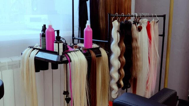 Hairdresser showcasing various hair extension samples and hair care products in a vibrant salon setting, highlighting options for clients seeking beauty and style enhancements