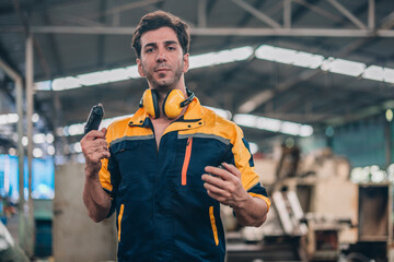 Skilled Worker in Industrial Workshop Poses Confidently With Tools in Hand