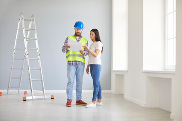 Skilled professional repairman explaining project plan, architect construction worker talking to client considering flat documents, planning collaborative building work, choosing paint, designing 