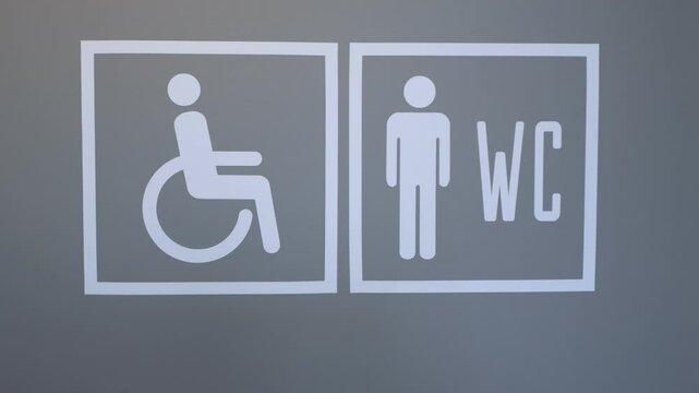 Signage for Public Restrooms Featuring Symbols Indicating Accessibility and Lift Usage