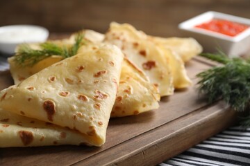 Delicious crepes and dill on table, closeup